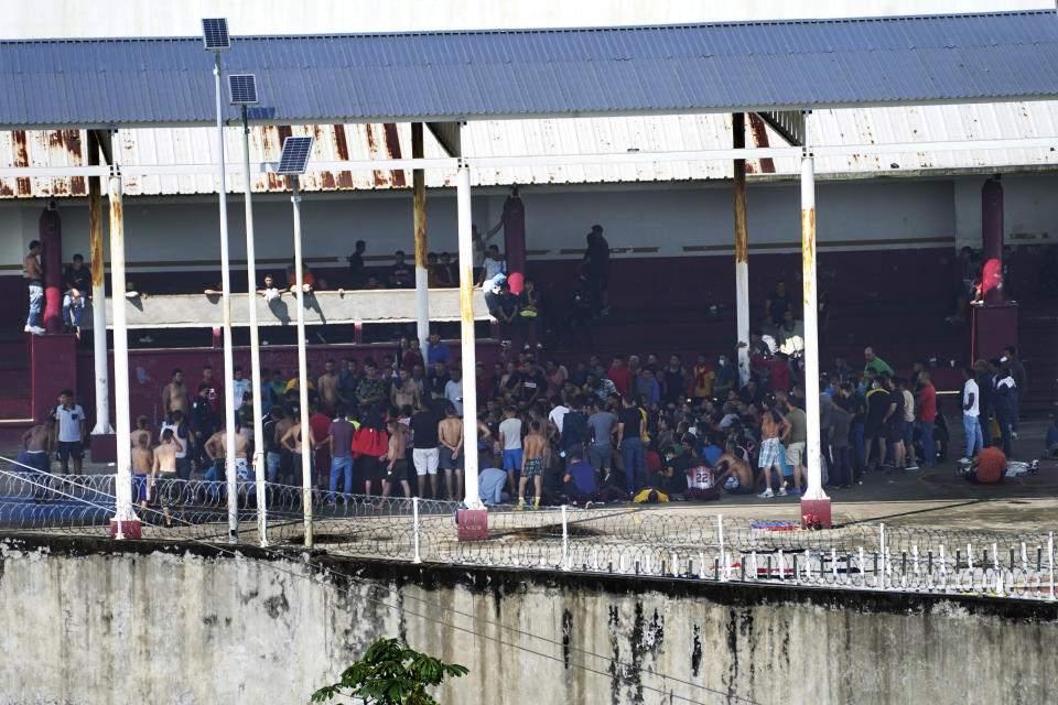 Detained migrants stand in the outdoor area of the Siglo XXI Migrant Detention Center in Tapachula, Chiapas state, Mexico, Tuesday, Oct. 4, 2022. Legal papers, freedom from detention, transit permits, temporary visas: All are available for a price via lawyers, fixers and middlemen. But even though the documents are legal and the cost can be several hundred dollars or more, migrants are at risk of arrest or return to their entry point as they make their way through the country, thanks to inconsistent policy enforcement and some corrupt officials at checkpoints. (AP Photo/Marco Ugarte)