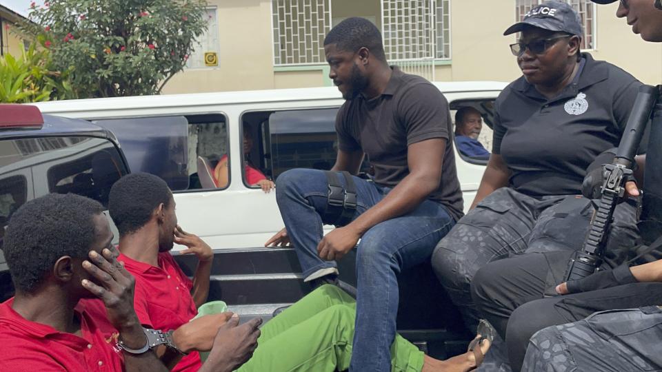 Police transport escaped prisoners Atiba Stanislaus, far left, and Trevon Robertson who are handcuffed together in Kingstown, St. Vincent and the Grenadines, Monday, March 4, 2024. The men had escaped from a police holding cell in Grenada on Feb. 18 and are suspected of hijacking a catamaran while Ralph Hendry and Kathy Brandel, who disappeared, were aboard. (AP Photo/Kenton Chance)