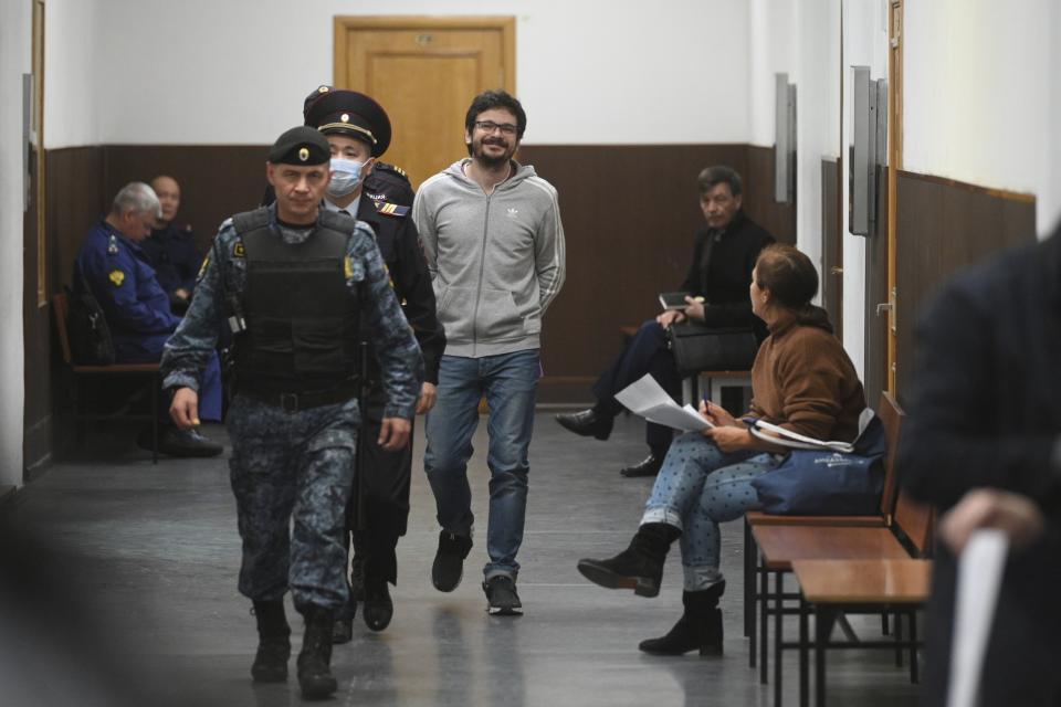 Russian opposition activist and municipal deputy of the Krasnoselsky district Ilya Yashin, center, is escorted to a court room prior to a hearing on his detention at the Basmanny district court in Moscow, Russia, Friday, Sept. 9, 2022. Yashin, 39, is one of the few prominent opposition figures that refused to leave Russia despite the unprecedented pressure the authorities have mounted on dissent in recent years. (AP Photo/Dmitry Serebryakov)