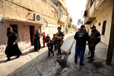 Federal police speak with civilians during a battle with Islamic State militants at Dawasa neighbourhood in Mosul, Iraq, March 8, 2017. REUTERS/Thaier Al-Sudani