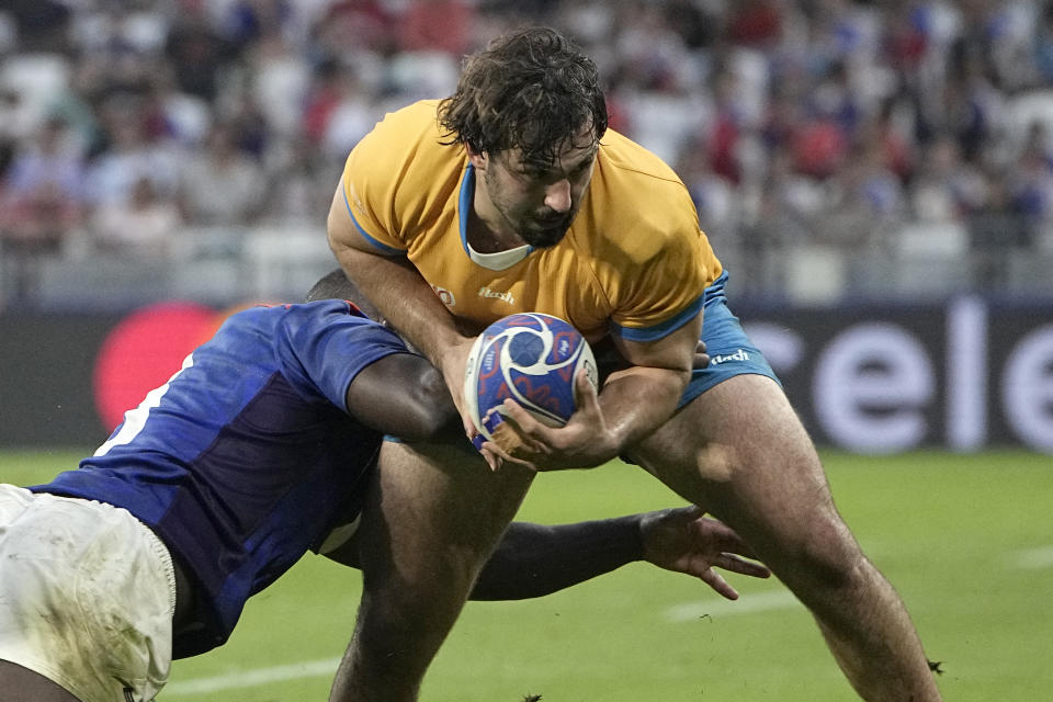 Uruguay's Manuel Ardao evades Namibia's Prince Gaoseb during the Rugby World Cup Pool A match between Uruguay and Namibia at the OL Stadium in Lyon, France, Wednesday, Sept. 27, 2023. (AP Photo/Laurent Cipriani)