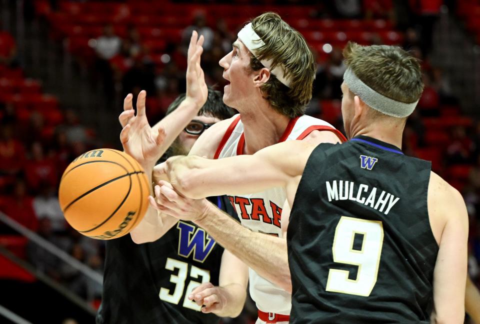 Utah Utes guard Rollie Worster (25) gets hit across both arms by Washington Huskies guard Paul Mulcahy (9) without a foul call as Utah and Washington play at the Huntsman Center at the University of Utah in Salt Lake City on Sunday, Dec. 31, 2023. | Scott G Winterton, Deseret News