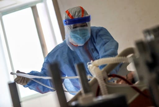 Un sanitario trata a un paciente infectado con coronavirus COVID-19 el 10 de marzo de 2020 en el Hospital de la Cruz Roja en Wuhan, China (AFP | Str)