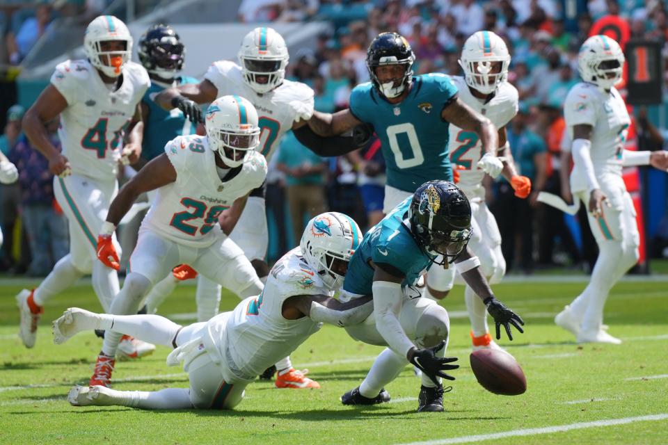 Sep 8, 2024; Miami Gardens, Florida, USA; Miami Dolphins safety Jevon Holland (8) punches the ball away from Jacksonville Jaguars running back Travis Etienne Jr. (1) causing a fumble that was recovered by the Dolphins in the end zone during the third quarter at Hard Rock Stadium. Mandatory Credit: Jim Rassol-Imagn Images