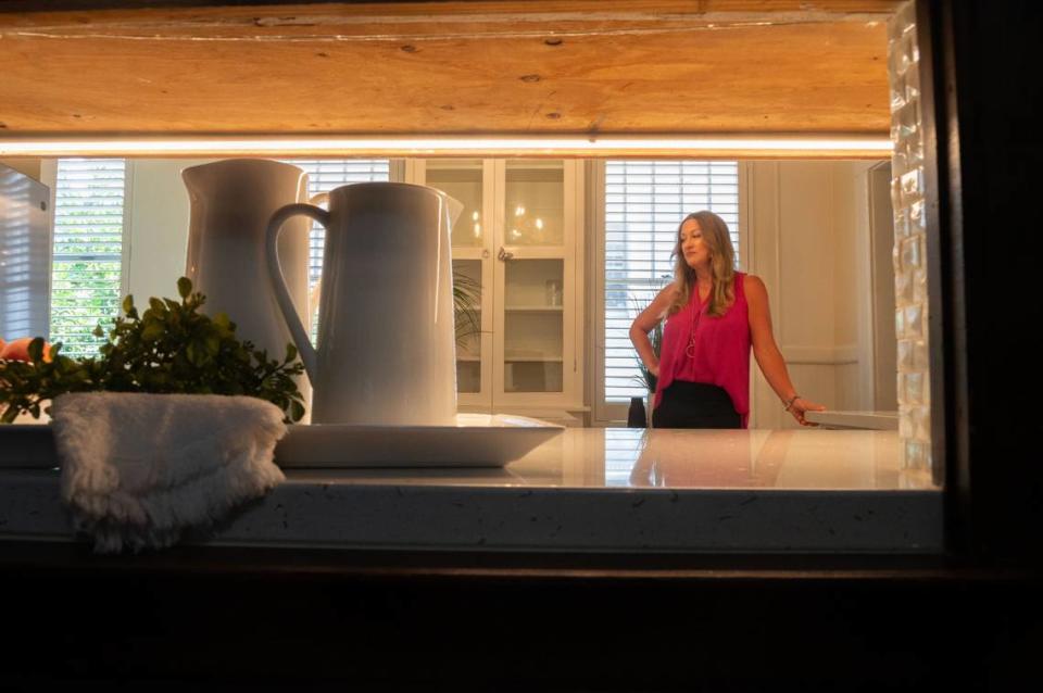 Emily Valdez with EXP Realty stands in the kitchen of the historic Wilder House in Sacramento’s Alkali Flat neighborhood on Monday. There is a pass through for food and dishes between the dining room and the kitchen.