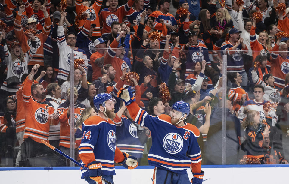 Edmonton Oilers' Mattias Ekholm (14) and Connor McDavid (97) celebrate a goal against he Dallas Stars during the third period of Game 4 of the Western Conference final in the NHL hockey Stanley Cup playoffs, Wednesday, May 29, 2024, in Edmonton, Alberta. (Jason Franson/The Canadian Press via AP)