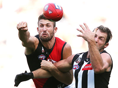 Cale Hooker gets a fist in as Travis Cloke goes to mark
