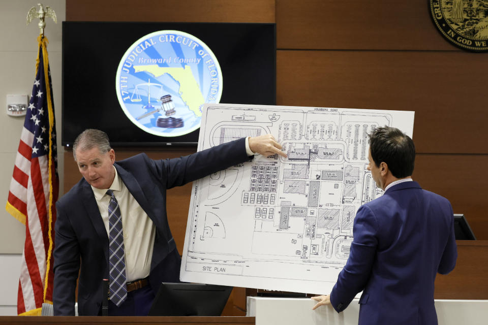 Using a diagram of the school, Coral Springs Police Sgt. Jeffrey Heinrich, left, speaks about his location and his understanding of the gunman's location during the 2018 shootings as he testifies during the trial of former Marjory Stoneman Douglas High School School Resource Officer Scot Peterson, Thursday, June 8, 2023, at the Broward County Courthouse in Fort Lauderdale, Fla. Peterson is charged with child neglect and other charges for failing to stop the Parkland school massacre five years ago. (Amy Beth Bennett/South Florida Sun-Sentinel via AP, Pool)