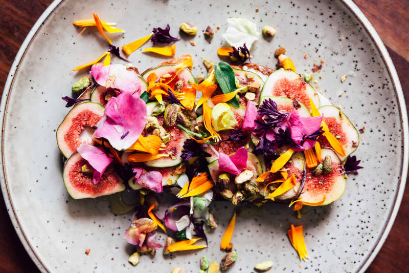 Fig toast with edible flowers, directly above view