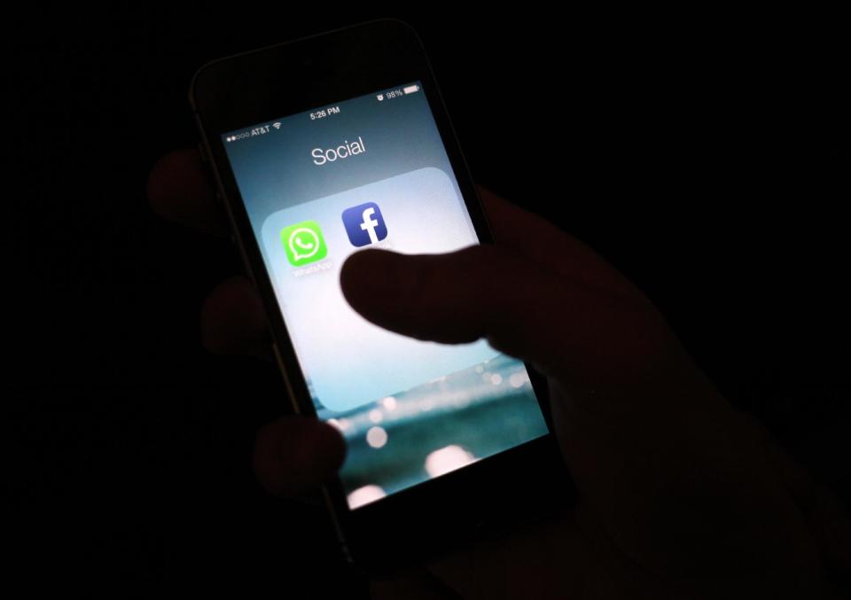 This Wednesday, Feb. 19, 2014 photo, shows the WhatsApp and Facebook app icons on an iPhone in New York. On Wednesday Facebook announced it is buying mobile messaging service WhatsApp for up to $19 billion in cash and stock. (AP Photo/Karly Domb Sadof)