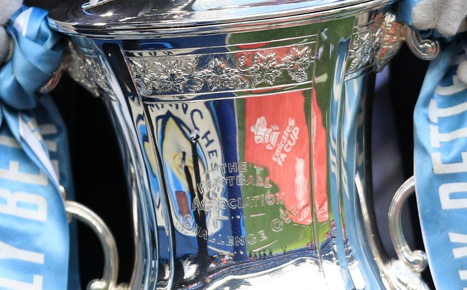 A general view of the Manchester City logo and Emirates FA Cup logo reflected in the trophy ahead of the FA Cup trophy during the Emirates FA Cup Third Round match between Manchester City and Huddersfield Town at Etihad Stadium on January 7, 2024 in Manchester, England.