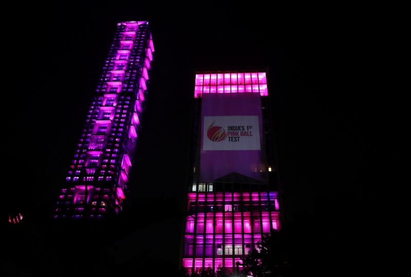 A Tata Steel office building and an under-construction high-rise residential tower are illuminated in pink on the first day of the first day-night test cricket match between India and Bangladesh using pink balls, in Kolkata