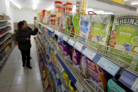 Chinese customers select food on a shelf where Heinz products are displayed in a market in Shanghai March 15, 2006. REUTERS/Stringer