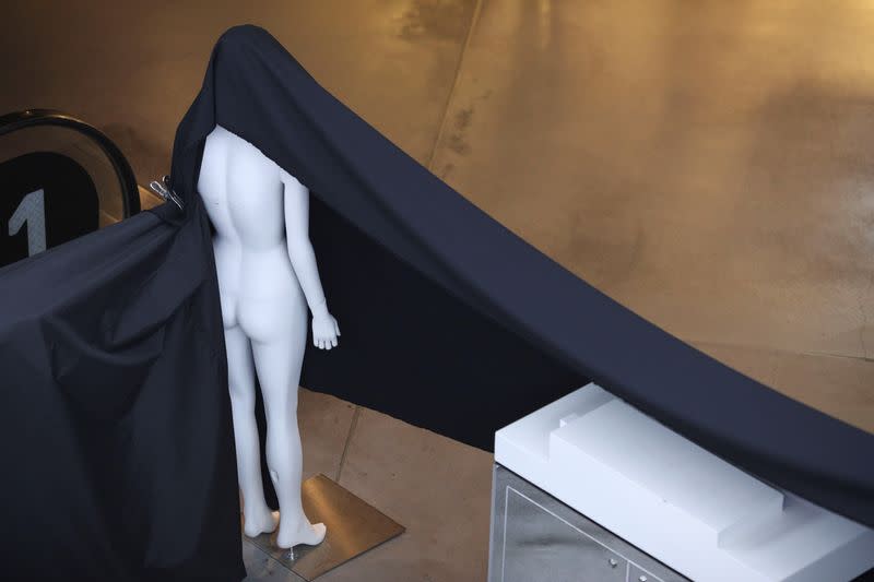 A mannequin is used to hang a piece of fabric on a closed business at a mall following the implementation of stricter social-distancing and self-isolation rules to limit the spread of the coronavirus disease (COVID-19) in Sydney