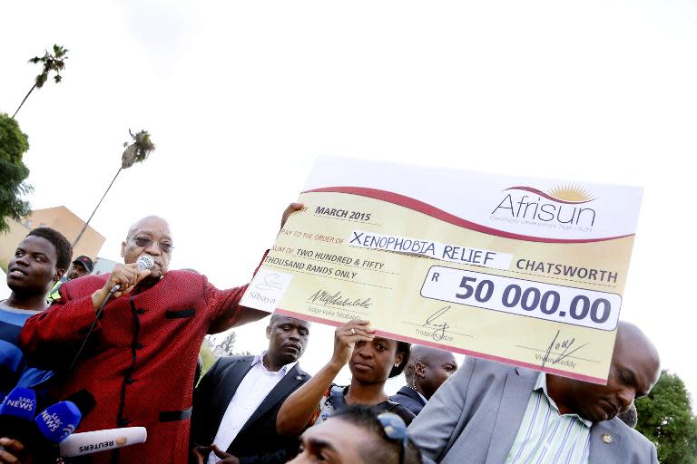 South African President Jacob Zuma displays a cheque that he donated to the foreign nationals at a temporary refugee camp in Chatsworth, south of Durban on April 18, 2015