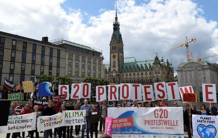 Protestors hold a banner in front of the townhall during a demonstration against the upcoming G20 summit in Hamburg, Germany June 26, 2017. REUTERS/Fabian Bimmer