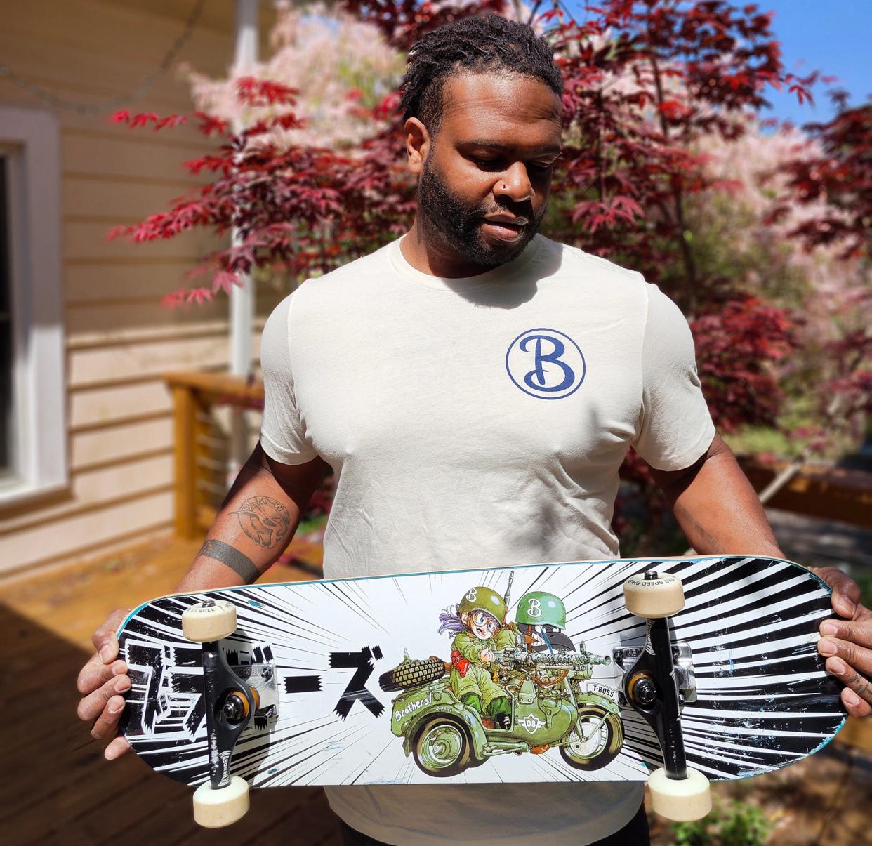 Kirin Thurman poses with a Chris Hobe-designed skateboard in Hull, Ga. on April 14, 2024. Kirin and his brother Khamisi will be co-hosting a skateboard art show with Hobe at Cine in Athens, Ga. on May 18, 2024.