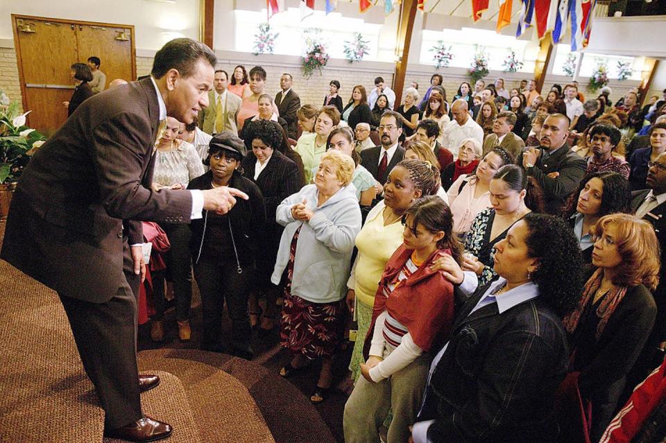 The Rev. Luciano Padilla welcomes visitors at the Bay Ridge Christian Center in New York City in 2005. <a href="https://www.gettyimages.com/detail/news-photo/reverend-luciano-padilla-offers-a-personal-welcome-to-first-news-photo/52983860?phrase=latino%20pentecostal&adppopup=true" rel="nofollow noopener" target="_blank" data-ylk="slk:Robert Nickelsberg/Getty Images;elm:context_link;itc:0;sec:content-canvas" class="link ">Robert Nickelsberg/Getty Images</a>