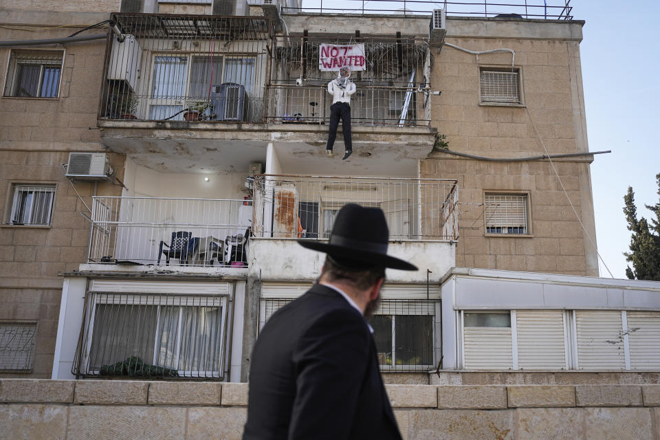 An effigy of Hamas leader Yehya Sinwar hangs off the balcony of an apartment under the sign "Not Wanted" in Jerusalem on Thursday, March 28, 2024. Israel says Sinwar is the mastermind of Hamas' deadly cross-border attack on Oct. 7 and says he remains in hiding in Gaza. (AP Photo/Ohad Zwigenberg)