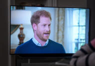 A person at home in Edinburgh watches Prince Harry, the Duke of Sussex, being interviewed by ITV's Tom Bradby, during "Harry: The Interview," two days before his controversial autobiography "Spare" is published, Sunday, Jan. 8, 2023. (Jane Barlow/PA via AP)