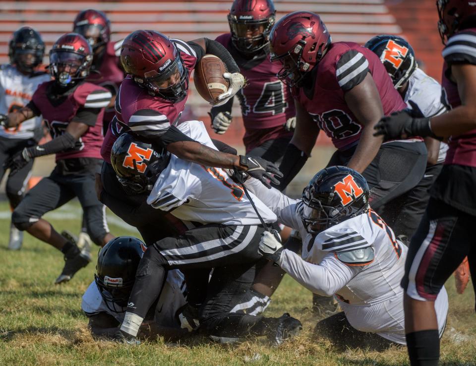 The Manual defense brings down Peoria running back Maliek Ross in the second half Saturday, Sept. 24, 2022 at Peoria Stadium.