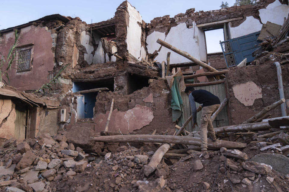 A man searches for valuables amid his home which was damaged by the earthquake in Ouirgane, outside Marrakech, Saturday, Oct. 7, 2023. Villagers in hard-hit regions are weighing how to best rebuild as Moroccan authorities begin to providing rehousing funds to those whose homes were destroyed by last month's earthquake. (AP Photo/Mosa'ab Elshamy)