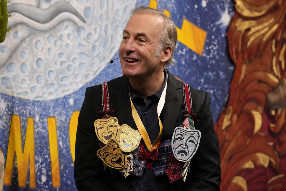 Actor Bob Odenkirk wears a bra adorned with theatrical masks during a roast while being honored as Man of the Year by Harvard University's Hasty Pudding Theatricals, Thursday, Feb. 2, 2023, in Cambridge, Mass. (AP Photo/Charles Krupa)