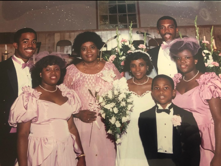 <span><span>Darius (left) with his mother (center holding a rose) in the 1980s</span><span>@dariusrucker/instagram</span></span>
