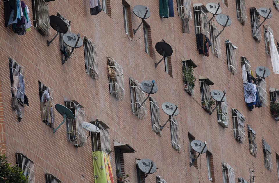 DirectTV satellite dishes dot the facade of the Great Mission public housing project in Caracas,Venezuela, Friday, May 22, 2020. Venezuela’s high court ordered on Friday the immediate seizure of all DirecTV property, days after the U.S. firm abandoned its services in the South American nation, citing U.S. sanctions. (AP Photo/Ariana Cubillos)