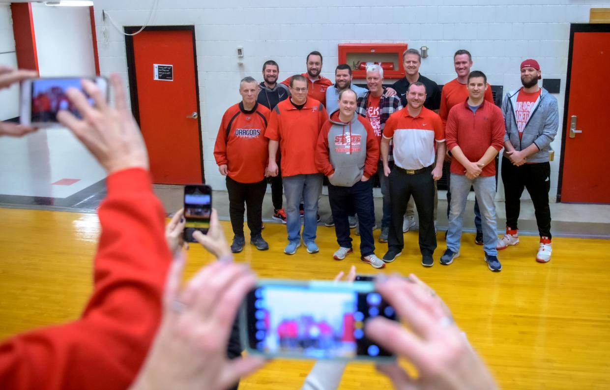 Members of the 2001-2002 Pekin Dragons boys basketball team gather for photos after a ceremony in their honor at halftime of a game between Pekin and East Peoria on Friday, Jan. 14, 2022 in Pekin. The Dragons fell to the Raiders 43-30.