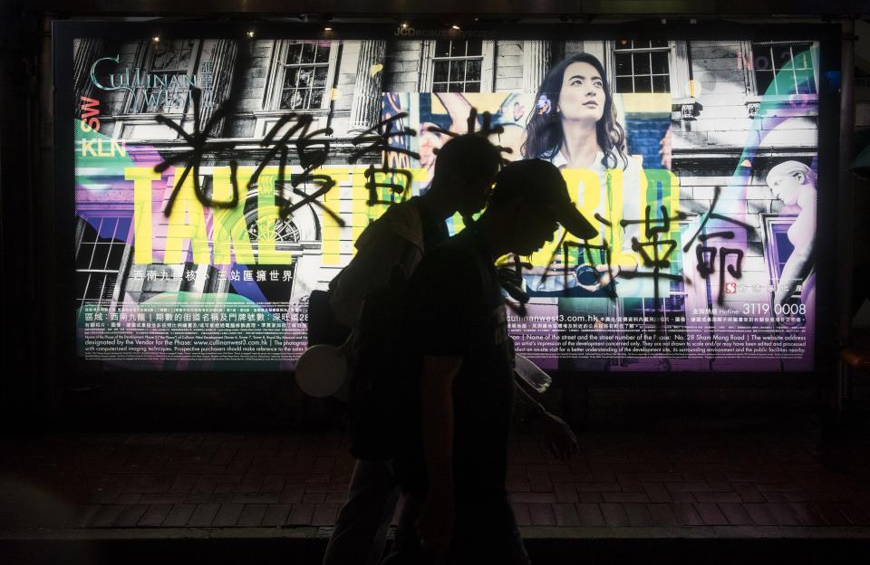 HONG KONG, CHINA - AUGUST 18: Demonstrators pass by a vandalized street advertisement during a protest organized by the Civil Human Rights Front, in Hong Kong, China on August 18, 2019. Large-scale protests in Hong Kong began last June against a bill to legalize the extradition of suspects to mainland China, Macao and Taiwan. (Photo by Miguel Candela/Anadolu Agency via Getty Images)