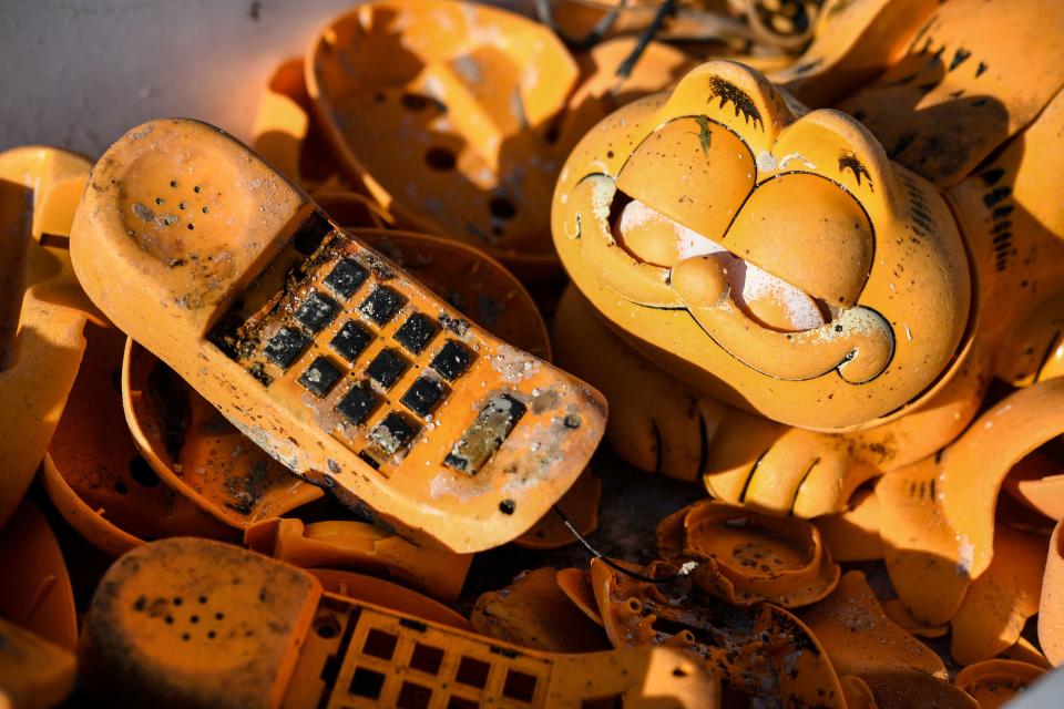 Parts of plastic Garfield phones on the beach of Plouarzel, western France, after being collected from a sea cave by environmental activists. Source: Fred Tanneau/AFP/Getty Images