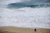 <p>A boogie boarder walks near the surf at Makapu’u Beach, Friday, Aug. 24, 2018, in Waimanalo, Hawaii. As Hurricane Lane approaches Oahu, large ocean swells have impacted the coastline. (Photo: Marco Garcia/AP) </p>