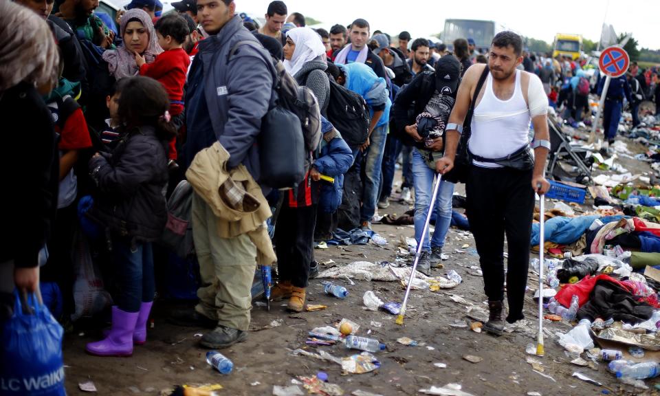 FILE - A man walks with crutches through a temporary holding center for migrants behind the border between Serbia and Hungary in Roszke, southern Hungary, Saturday, Sept. 12, 2015. Germany's conservative opposition leader Friedrich Merz said Tuesday that large-scale migration is one of the country's biggest problems and one of the main reasons for the recent surge in support for the far right. (AP Photo/Matthias Schrader, File)