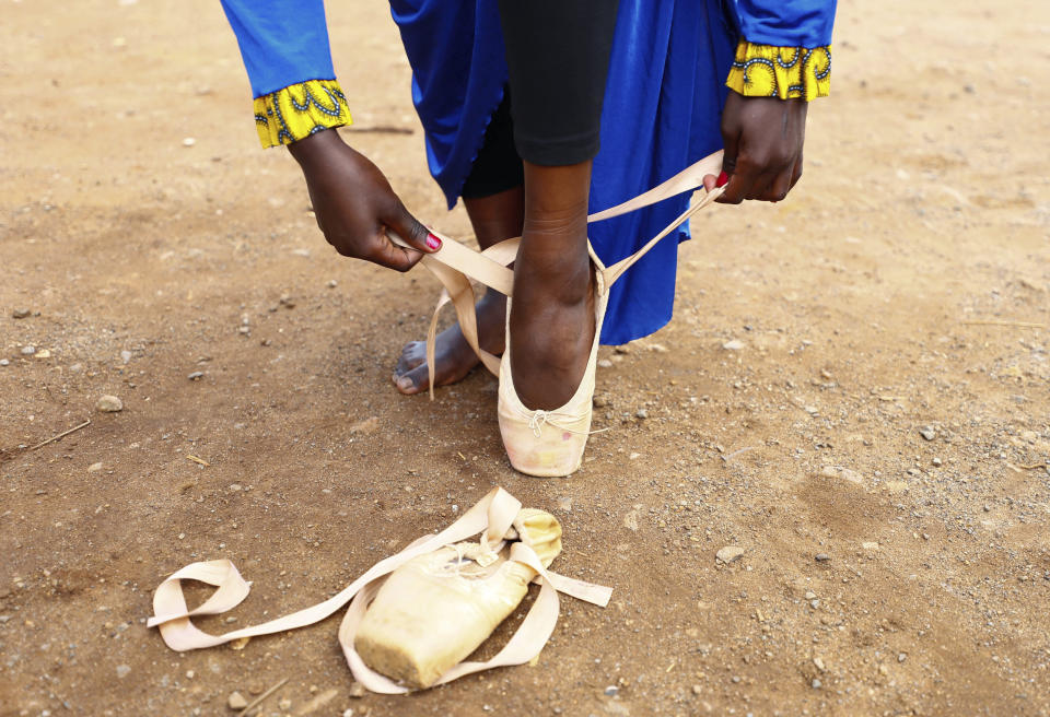 A young dancer ties her pointe shoes in preparation to dance in a Christmas ballet event in Kibera, one of the busiest neighborhoods of Kenya's capital, Nairobi, Friday, Dec. 15, 2023. The ballet project is run by Project Elimu, a community-driven nonprofit that offers after-school arts education and a safe space to children in Kibera. (AP Photo/Brian Inganga)