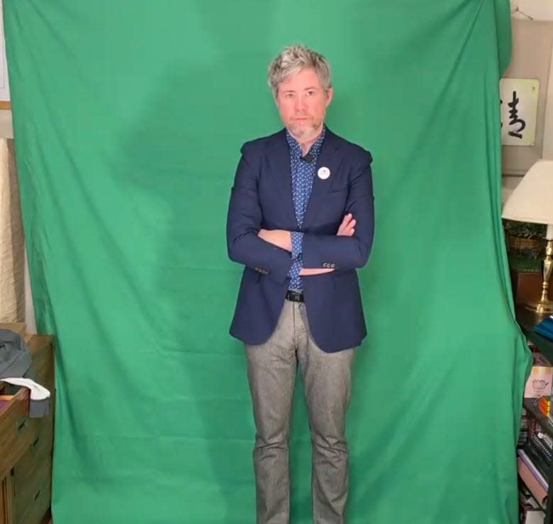 Austin Tyler Rogers stands in front of a green screen.