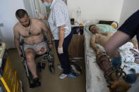 Medics bandage the wound of a Ukrainian serviceman at St. Panteleimon hospital in Lviv, Ukraine, Tuesday, July 25, 2023. At a rehabilitation hospital in the western city of Lviv, soldiers rely as much on each other as they do upon the physicians and rehabilitation specialists they will need to adapt to their new prostheses. (AP Photo/Evgeniy Maloletka)