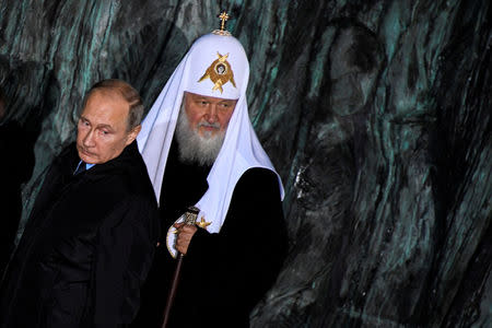 FILE PHOTO: Russian President Vladimir Putin and Patriarch Kirill, the head of the Russian Orthodox Church, attend a ceremony unveiling the country's first national memorial to victims of Soviet-era political repressions called "The Wall of Grief" in Moscow, Russia October 30, 2017. REUTERS/Alexander Nemenov/Pool/File Photo