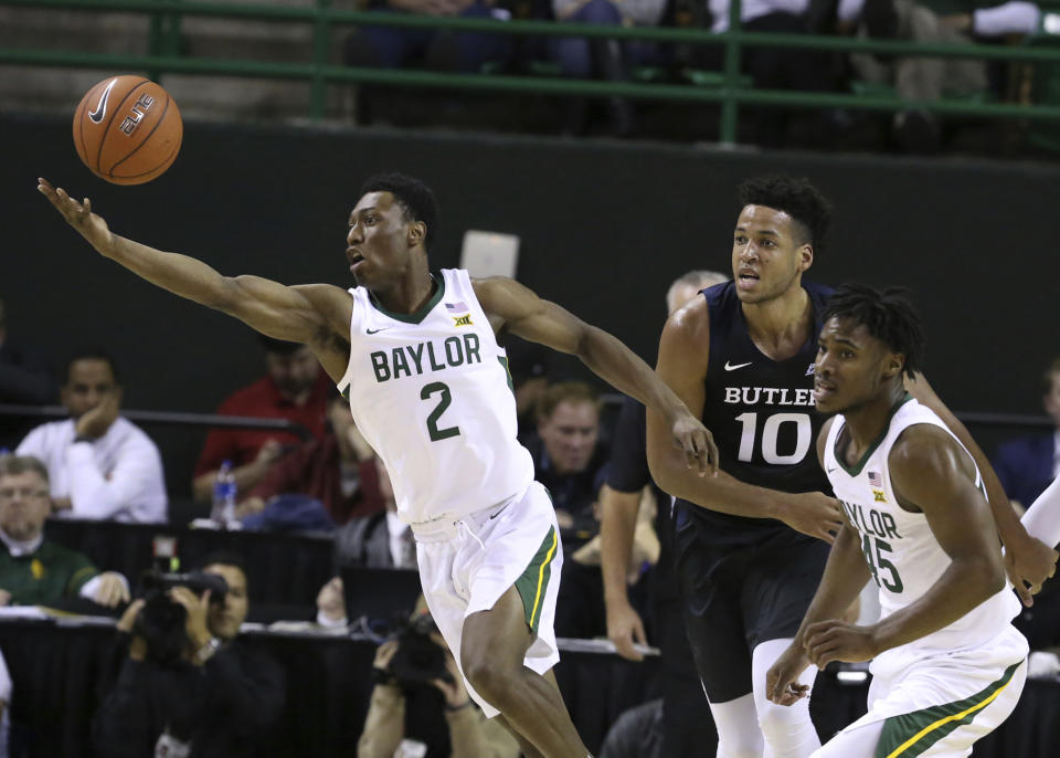 Baylor guard Devonte Bandoo, left, reaches for a loose rebound past Butler forward Bryce Nze, center, and guard Davion Mitchell, right, in the first half of an NCAA college basketball game, Tuesday, Dec. 10, 2019, in Waco, Texas. (AP Photo/Rod Aydelotte)