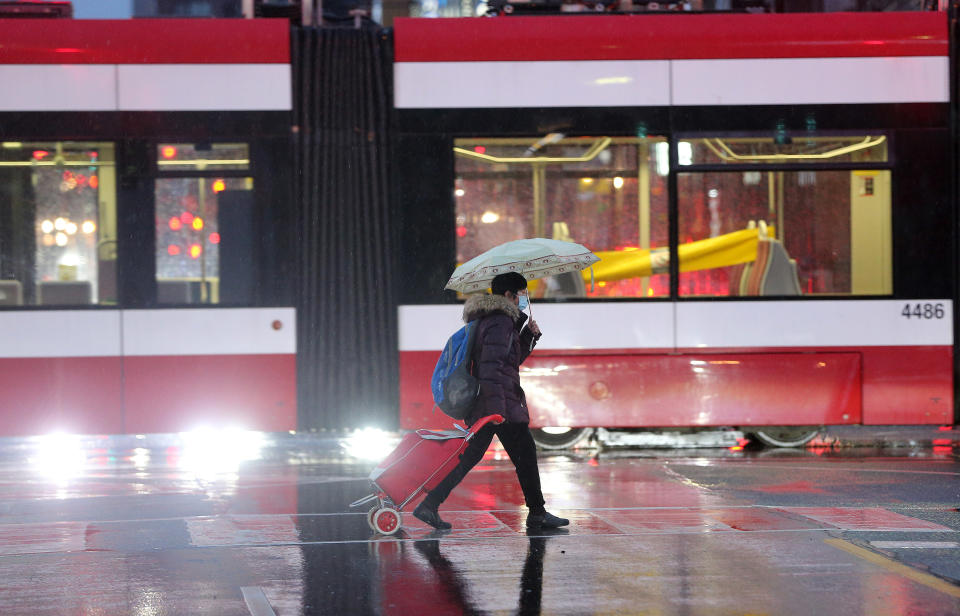 TORONTO, ON- DECEMBER 24 - Shoppers walk cross near Yonge-Dundas Square on Christmas Eve. Ontario faces stricter restrictions to slow the spread of the COVID-19 pandemic in Toronto. December 24, 2020. (Steve Russell/Toronto Star via Getty Images)