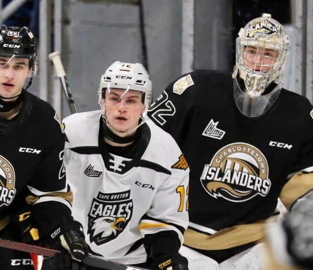 Charlottetown Islanders goaltender Colten Ellis, right, looks around Cape Breton Eagles forward Jack Campbell and Islanders defenceman Sean Stewart earlier this month at Centre 200 in Sydney, N.S. A game between the two teams on Sunday was cancelled due to illness. (Mike Sullivan - image credit)