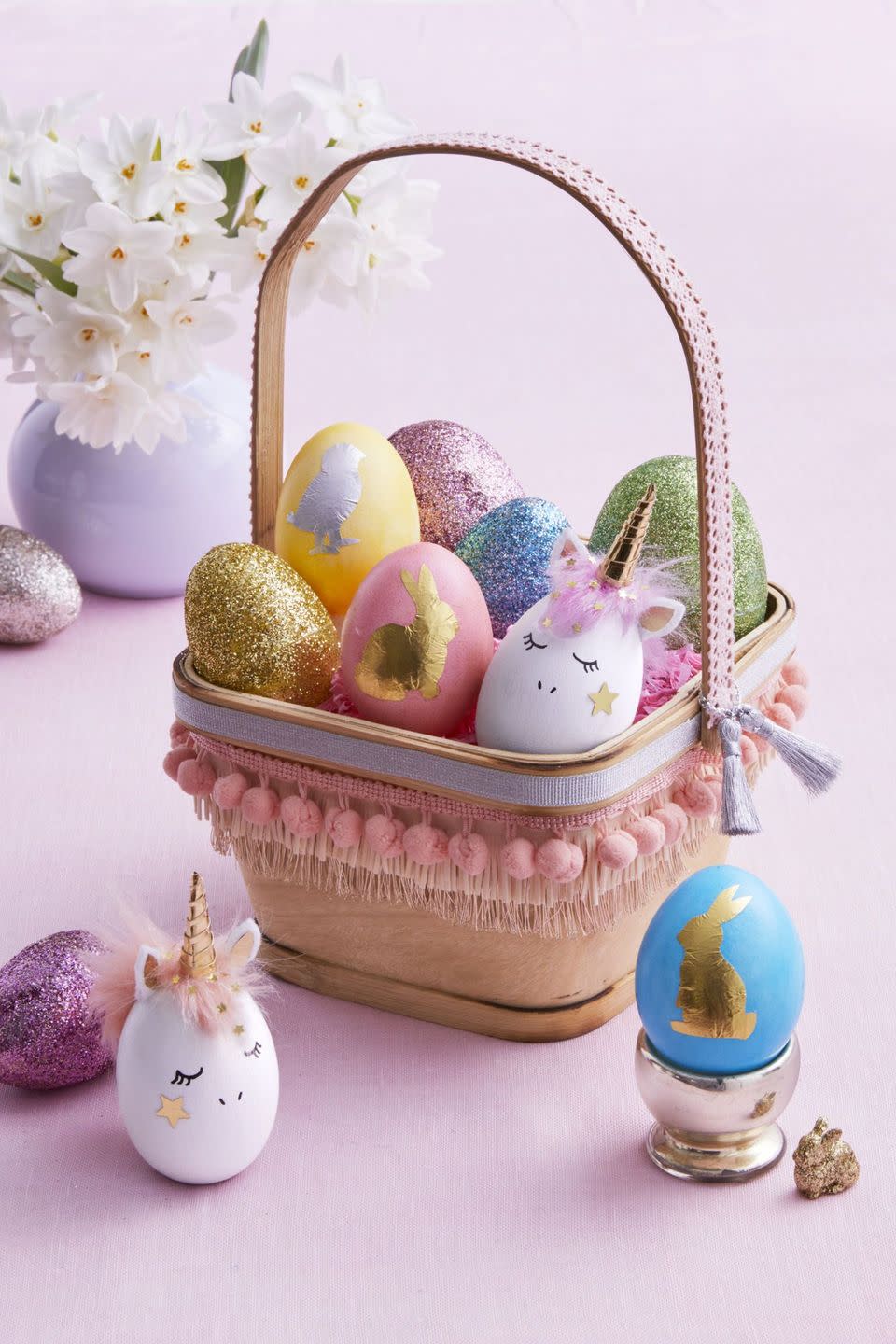 <p>Make a plain square basket look magical with a few scraps of ribbon and trim, and fill with unicorn-inspired and sparkling Easter eggs.</p><p><strong>Lovely Unicorn:</strong> Paint a wooden egg white; let dry. Draw on face. Cut a mane from faux-fur trim, color in an egg dye bath, and attach (once dry) with fabric glue. Use templates to make felt ears and a gold paper horn; assemble and glue to egg. Wrap a 3 x 1/8-in. strip of gold paper around horn; secure with glue. Glue star confetti to cheek and hair.</p><p><strong>Shiny Silhouette:</strong> Use the templates to carefully cut a chick or bunny from a foil candy wrapper. Adhere to dyed egg with Mod Podge. Use a damp cotton swab to gently wipe clean the foil shape; let dry.</p><p><strong>Dazzling Glitter Egg:</strong> Try this trick on basic plastic eggs: Lightly sand the outside, brush on glue, cover in glitter, and let dry.</p><p><strong><em><a href="https://www.womansday.com/home/crafts-projects/a18837631/easter-egg-templates/" rel="nofollow noopener" target="_blank" data-ylk="slk:Get the templates here.;elm:context_link;itc:0;sec:content-canvas" class="link ">Get the templates here.</a></em></strong></p><p><strong><a class="link " href="https://www.amazon.com/Supplies-Resistant-Polyester-Eyeshadow-Assorted/dp/B076J9RD8P/?tag=syn-yahoo-20&ascsubtag=%5Bartid%7C10070.g.1751%5Bsrc%7Cyahoo-us" rel="nofollow noopener" target="_blank" data-ylk="slk:SHOP GLITTER;elm:context_link;itc:0;sec:content-canvas">SHOP GLITTER</a></strong></p>