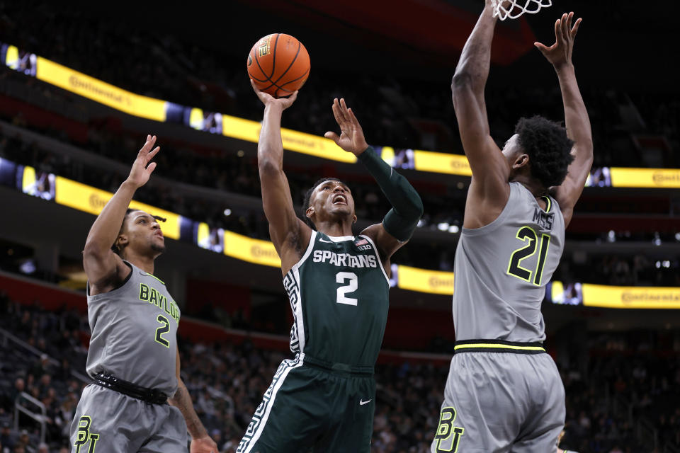 Michigan State guard Tyson Walker, center, shoots between Baylor guard Jayden Nunn (2), left, and Baylor center Yves Missi (21) during the first half of an NCAA college basketball game, Saturday, Dec. 16, 2023, in Detroit. (AP Photo/Al Goldis)