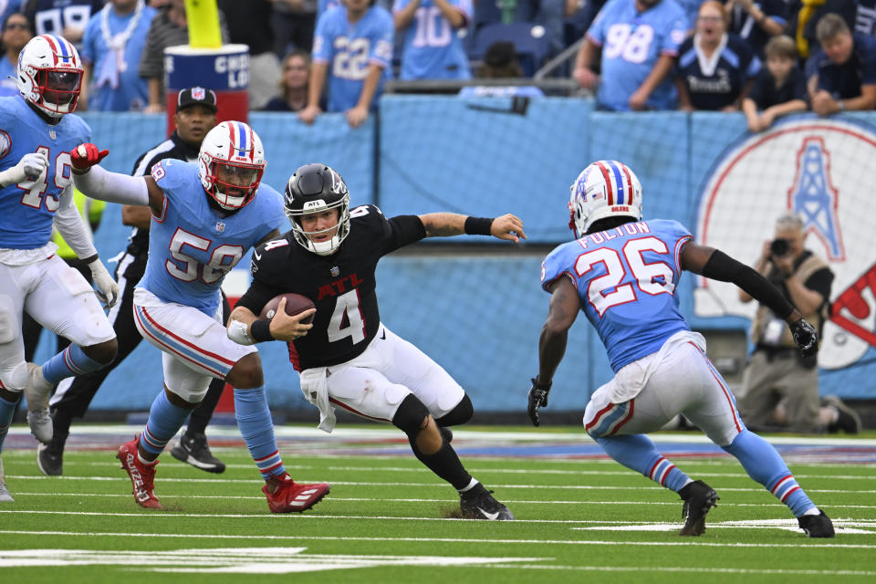 Atlanta Falcons quarterback Taylor Heinicke (4) scrambles as Tennessee Titans' Harold Landry III (58) and T Kristian Fulton (26) defend during the second half of an NFL football game, Sunday, Oct. 29, 2023, in Nashville, Tenn. (AP Photo/John Amis)