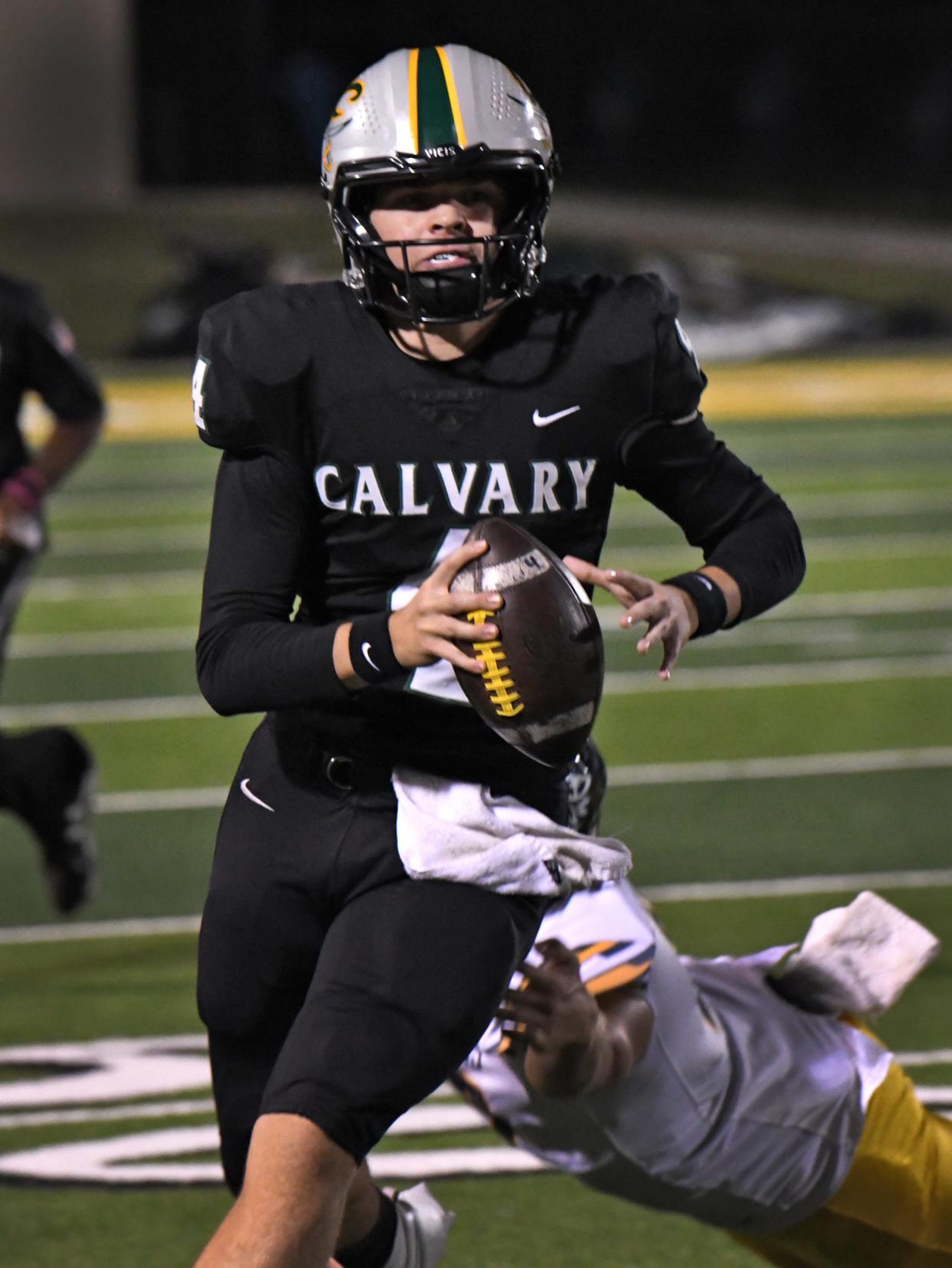 Calvary's Abram Wardell runs and looks an open receiver down field against D'Arbonne Woods Friday 10-20-23.