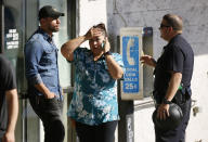 <p>An unidentified Trader Joe’s supermarket employee, center, talks on her phone as Los Angeles Police evacuate a group of witnesses. (Photo: Damian Dovarganes/AP) </p>