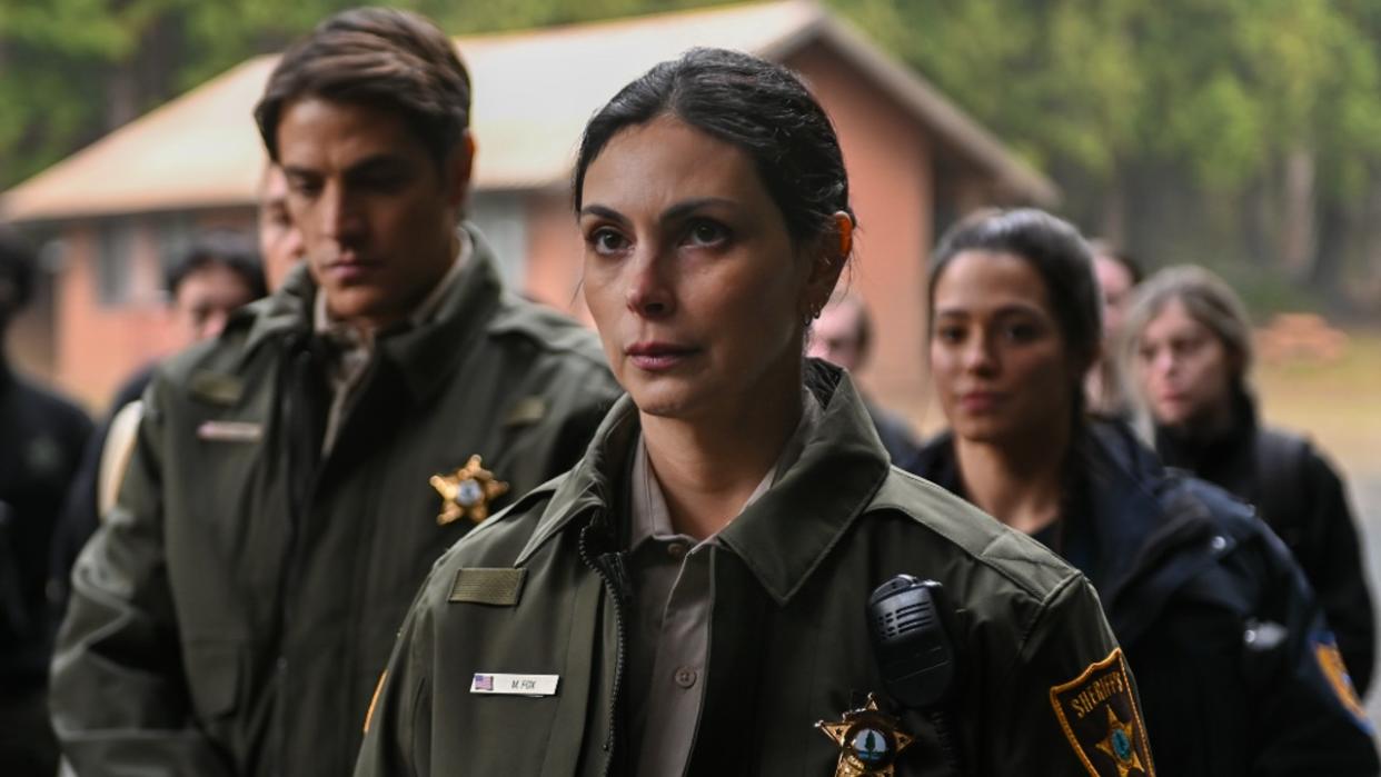  Morena Baccarin standing in front of other officers from the Sheriff's department in Fire Country. 