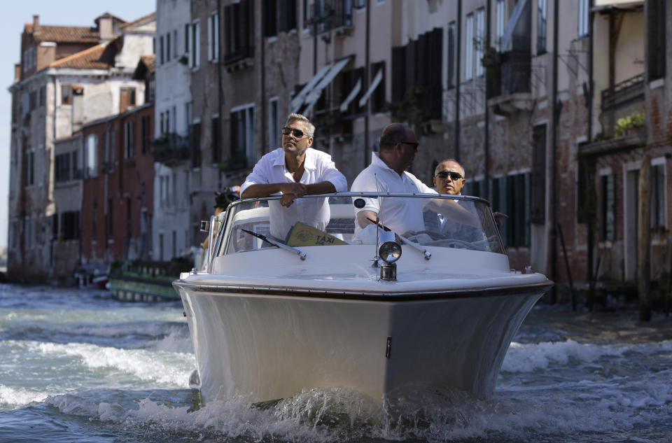 File - Actor George Clooney arrives in Venice, Italy on a taxi boat for the Venice Film Festival. The 77th Venice Film Festival will kick off on Wednesday, Sept. 2, 2020, but this year's edition will be unlike any others. Coronavirus restrictions will mean fewer Hollywood stars, no crowds interacting with actors and other virus safeguards will be deployed. (AP Photo/Joel Ryan, File)