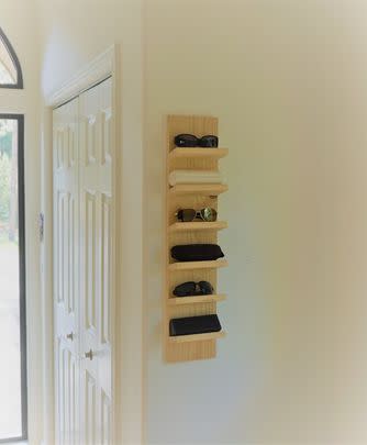 A mounted shelf with a magnetic keychain holder and room for up to 10 pairs of glasses