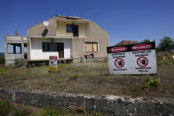 A sign saying "Access forbidden to unauthorized persons" is displayed in front of a house bought by Rio Tinto company in the village of Gornje Nedeljice, in the fertile Jadar Valley in western Serbia, Tuesday, Aug. 6, 2024. (AP Photo/Darko Vojinovic)